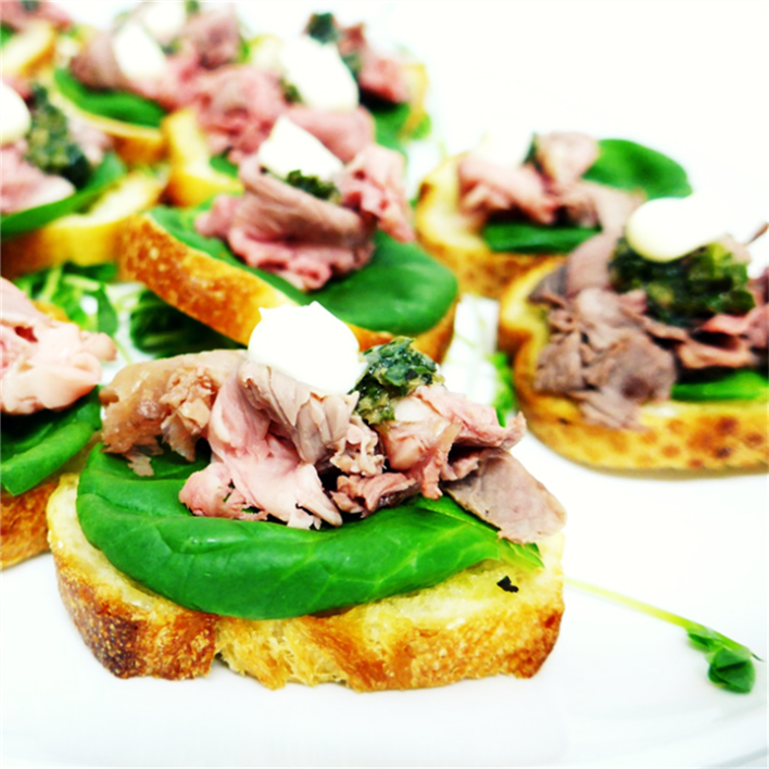 Baguette slices with roast beef and salsa verde