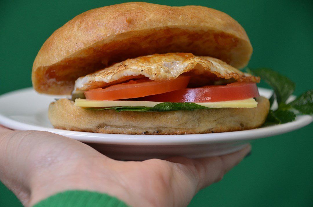 New York bagel filled with fried egg, spinach, cheddar, chutney