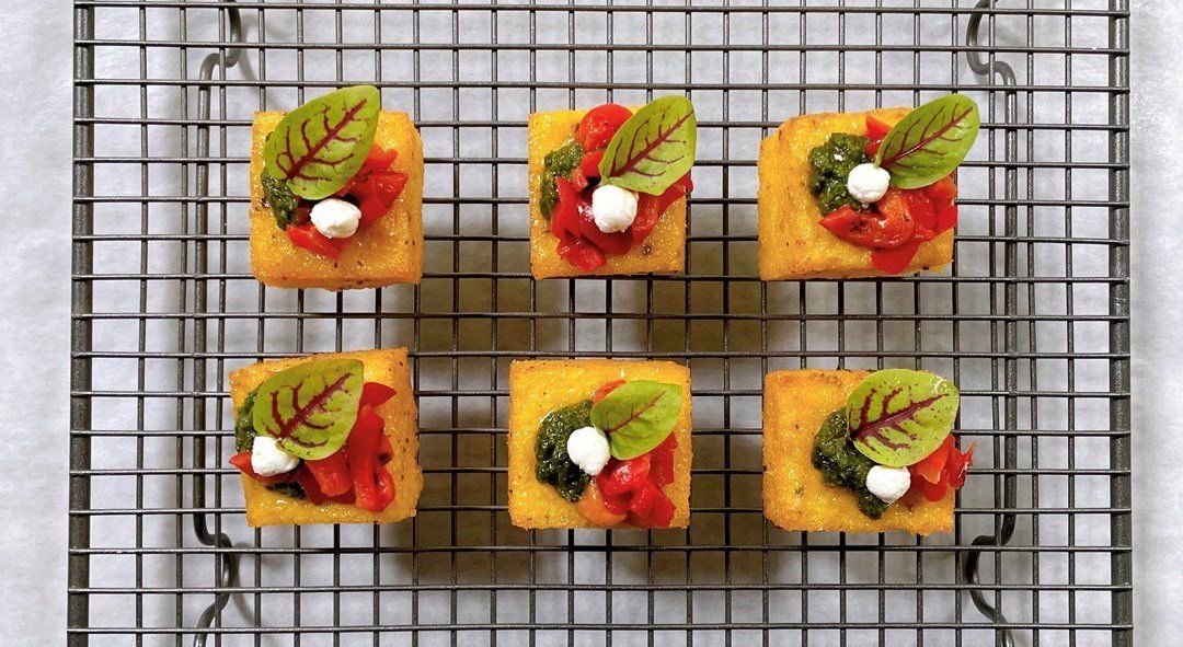 Polenta squares w red peppers, goat’s cheese & macadamia pesto