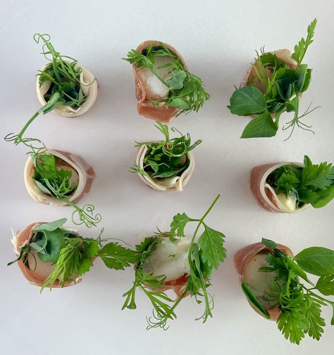 Poached tiger prawn prosciutto, yuzu cream & pea shoots. (NAG)